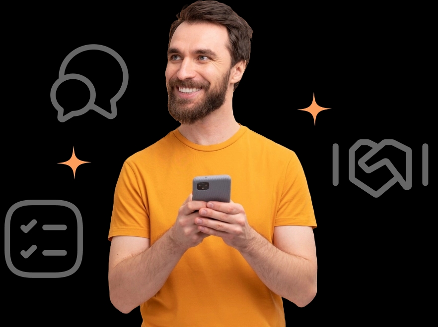 Homem com barba e de pele branca sorrindo com um celular nas mãos