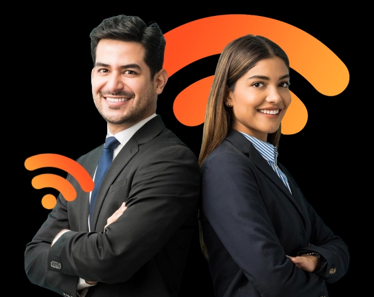 Um homem e uma mulher estão lado a lado, de costas um para o outro, ambos sorrindo. O homem tem cabelos escuros e curtos, veste um terno preto com gravata azul e camisa branca. A mulher tem cabelos castanhos compridos, usa um blazer preto, camisa listrada azul e branca. Ambos têm uma postura confiante, com os braços cruzados, parecendo profissionais em um ambiente de trabalho formal.