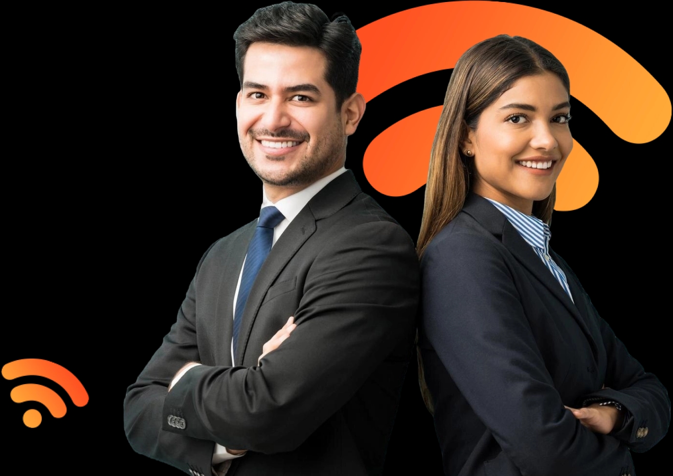 Um homem e uma mulher estão lado a lado, de costas um para o outro, ambos sorrindo. O homem tem cabelos escuros e curtos, veste um terno preto com gravata azul e camisa branca. A mulher tem cabelos castanhos compridos, usa um blazer preto, camisa listrada azul e branca. Ambos têm uma postura confiante, com os braços cruzados, parecendo profissionais em um ambiente de trabalho formal.