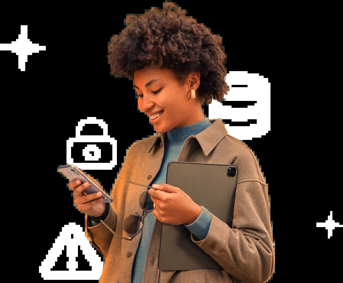 Uma mulher com cabelo curto e crespo segura um celular na mão esquerda e um tablet escuro na mão direita. Ela está olhando para o celular. Ícones de cadeado, uma base de dados e um triângulo de aviso estão ao redor.