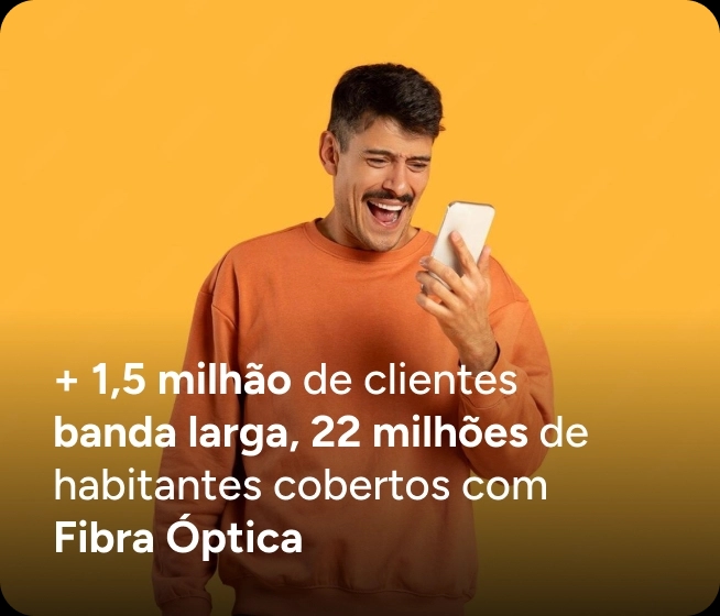 Homem vestindo blusa laranja segura um smartphone à frente do rosto contra um fundo amarelo sólido. O texto na parte inferior diz: "+ 1,5 milhão de clientes banda larga, 22 milhões de habitantes cobertos com Fibra Óptica".