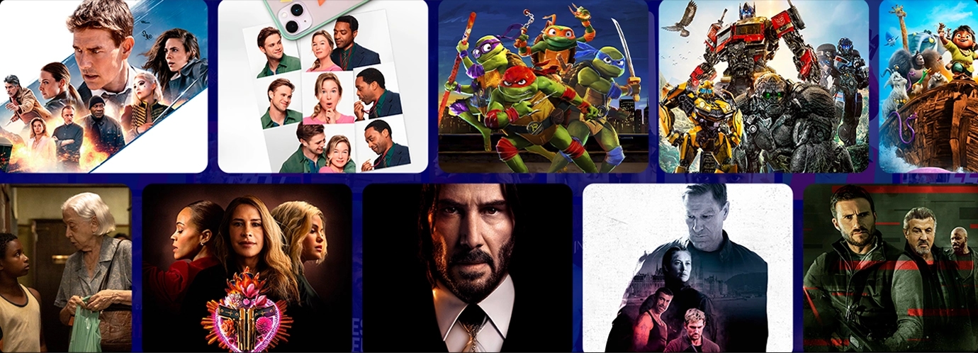 Mulher com controle remoto na mão e pipoca ao lado sentada em um sofá ao lado de uma criança. Ao fundo, um homem em péno balcão da cozinha, usando um laptop.