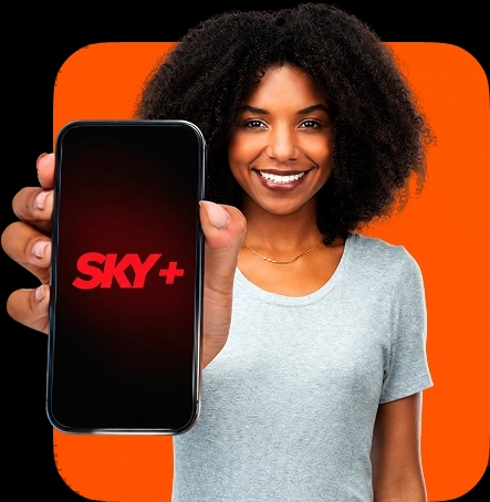 Mulher negra segura um smartphone em primeiro plano, exibindo a tela com o logotipo da SKY+. Uma forma quadrada com cantos arredondados está posicionada atrás dela.