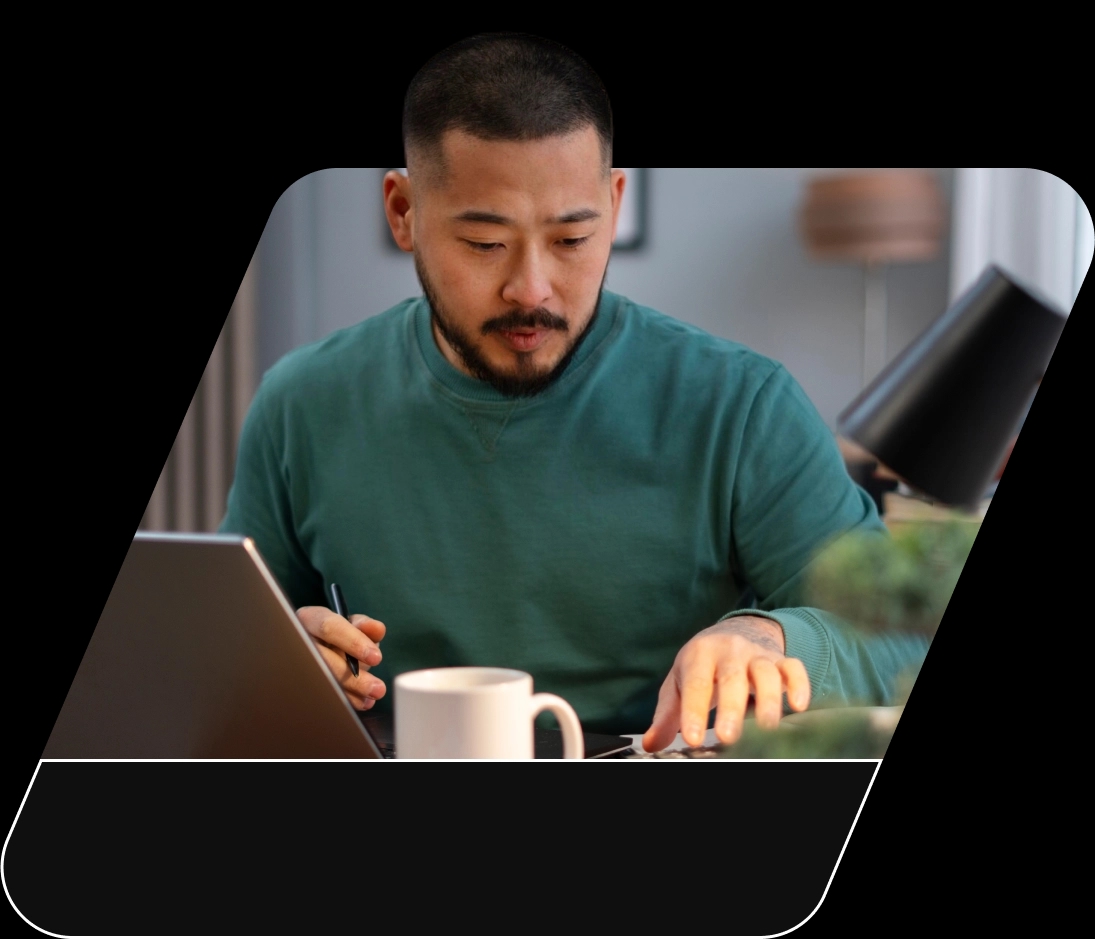 Homem de pele branca concentrado trabalhando com seu computador notebook em sua residência