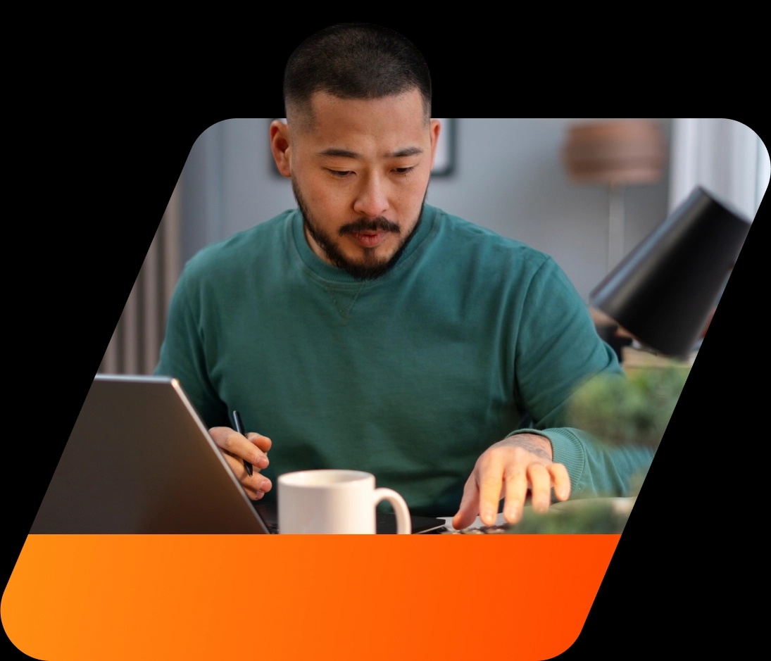 Homem de pele branca concentrado trabalhando com seu computador notebook em sua residência